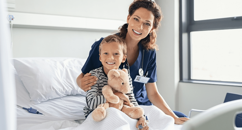 pediatric female nurse sitting with child with teddy bear
